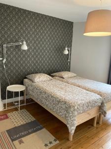 格朗维尔L'escale Granvillaise的一间小卧室,配有两张床和一盏灯