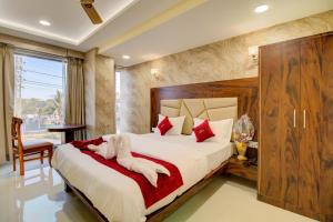 DiveHotel Samaira Residency,Dombivali的一间卧室配有一张带红色枕头的大床