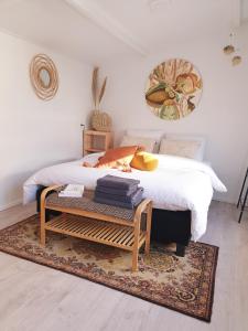 诺德韦克Little Lodge Noordwijk aan Zee的一间卧室配有一张床、一张桌子和毛巾