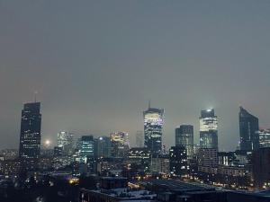 华沙City View Apartments的城市天际线,夜晚有灯光的建筑