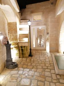 马泰拉5 Elementi Sassi Matera的一条铺有石地板的走廊和一条光线充足的楼梯