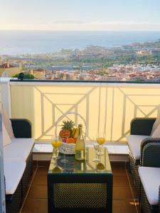 阿德耶Duplex Penthouse Panoramic Del Atlantico的阳台上的桌子上摆放着一瓶葡萄酒和玻璃杯