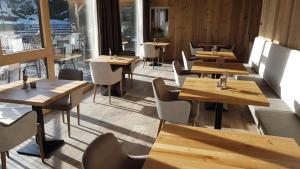 拉伊翁Hotel Andechserhof & Mountain Sky的餐厅设有木桌、椅子和窗户。