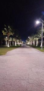 希法Studio Jebel Sifah Resort Golf Lake G 14 - 201的一条空的街道,晚上有棕榈树和街灯
