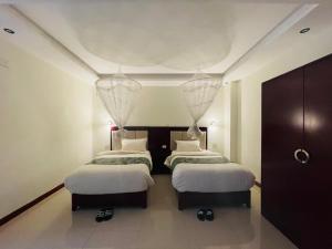 巴赫达尔Winn Hotel - Bahir Dar的配有2张床的白色墙壁和天花板客房