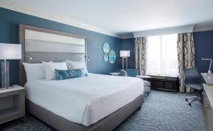 奥兰多奥兰多会议中心罗森中心酒店的酒店客房设有一张大床和一张书桌。