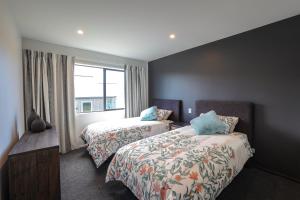 特卡波湖The Landsborough Tekapo的酒店客房设有两张床和窗户。