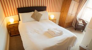 爱丁堡老约克宾馆的一间卧室配有一张带两盏灯的大型白色床。