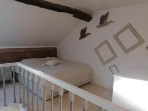 WaysL'autre rive de la Tourelle的卧室配有一张床,墙上有鸟儿