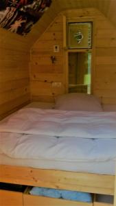 Gorenjcj扬科维奇露营地的木制客房内的一张大床,设有窗户