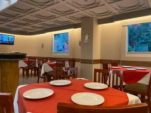 墨西哥城HOTEL MARIA RICO的餐厅配有桌椅和红色桌布