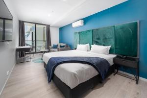 奥克利Oros Hotel and Apartments的一间卧室设有一张蓝色墙壁的大床
