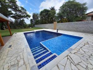 容迪亚伊Chácara com Piscina-JundiaÍ SP的后院的蓝色海水游泳池