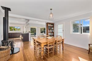 Waipu CoveSomerton - Waipu Holiday Home的厨房以及带桌椅的用餐室。