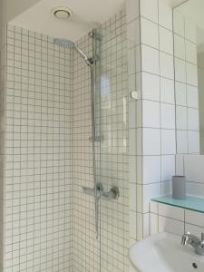 哥本哈根ApartmentInCopenhagen Apartment 1141的水槽旁的玻璃门淋浴