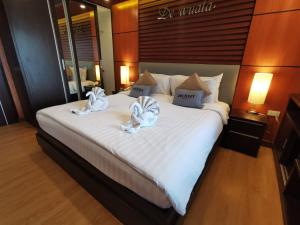 清迈Hotel De Wualai-SHA Extra Plus的一间卧室配有一张大床和毛巾