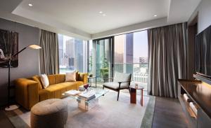 香港The Hari Hong Kong的客厅设有黄色的沙发和大窗户