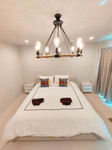 Ban RangengThe Nakara Town的一间卧室配有一张带吊灯的大床