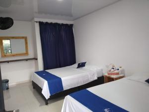 比利亚维哈Cosmos Tatacoa Hotel的酒店客房设有两张床和窗户。