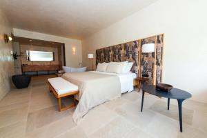 科林比亚Port Royal Villas and Spa - Adults Only的卧室配有一张白色的大床和一张桌子