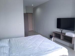 曼谷AFP Residence Hotel的一间卧室配有一张床和一台平面电视