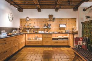 蒂罗尔-基希贝格Gasthaus Obergaisberg的一个带木制橱柜和长凳的大厨房
