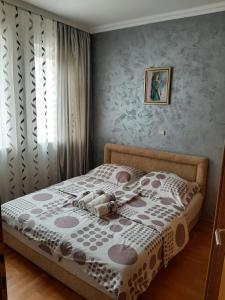 弗尔尼亚奇卡矿泉镇Maza Lux的卧室配有一张带白色和灰色棉质床罩的床。