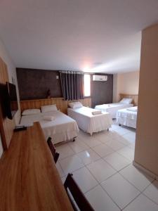 因佩拉特里斯Borges Hotel的酒店客房设有两张床和一张桌子。