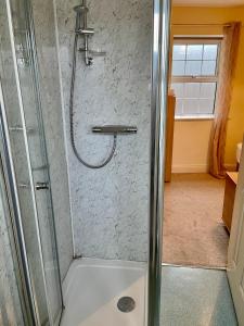 米德尔顿安斯托尔联排别墅旅馆的浴室里设有玻璃门淋浴