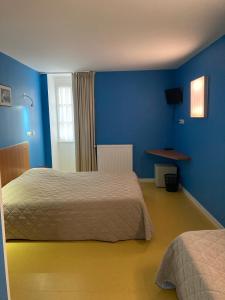 圣奈L'ETAPE DE SANTENAY的一间卧室设有两张床和蓝色的墙壁