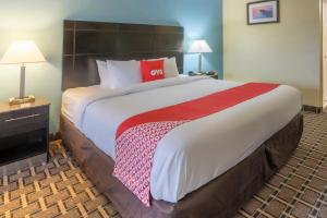 诺克斯维尔OYO Hotel Knoxville TN Cedar Bluff I-40的一张位于酒店客房内的大床,配有红色枕头