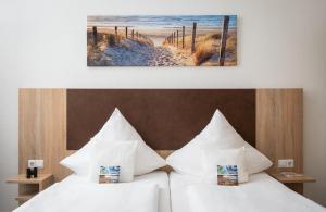 博尔库姆博尔库姆诺德希酒店的酒店的客房内设有两张带白色枕头的床。