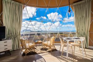 特吉塞Eslanzarote Luxurious Eco Dome Experience的客房设有桌椅和大窗户。