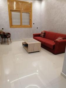 卡萨布兰卡Joli appartement Casablanca ain sebaa的客厅配有红色沙发和茶几