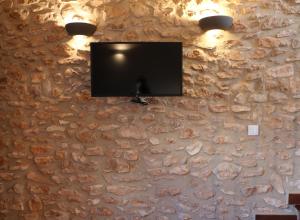 UserasCasa Rural Mas dels Fumeros的挂在石墙上的平面电视