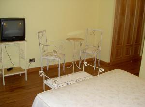 圣莱奥纳尔多德阿格曼里克拉拉酒店的一间卧室配有两把椅子、一张桌子和一台电视。