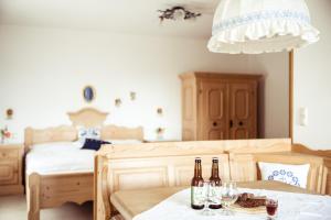 NeukirchenFrühstückspension Windlegern的一间设有两张床的房间和一张桌子上的两瓶葡萄酒