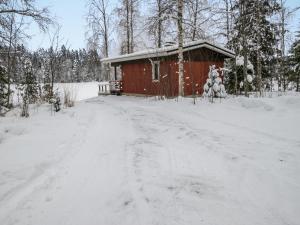 JuhanalaHoliday Home Lepikko by Interhome的一条雪覆盖的道路,通往红色小屋
