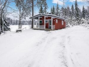 JuhanalaHoliday Home Mäntylä by Interhome的泥路上雪中的红色小屋