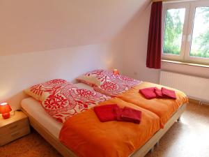 Süderneuland ZweiApartment Landblick-2 by Interhome的一间卧室配有带橙色床单和枕头的床。