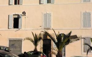 马赛文艺复兴酒店的一座带窗户和棕榈树的大型建筑