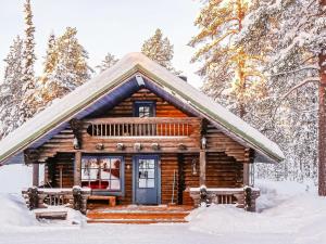 列维Holiday Home Tikkatupa by Interhome的雪中树林里的小木屋
