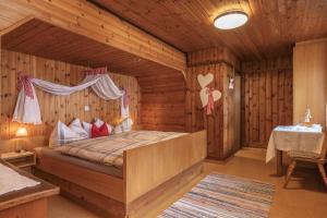 Fresach斯塔纳霍夫农家乐的小木屋内一间卧室,配有一张床
