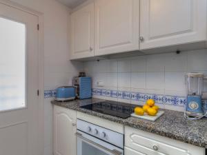 帕尔斯Apartment Golf Royal Delta by Interhome的厨房配有白色橱柜和柜台上的一盘水果
