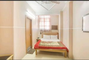 哈里瓦奎因酒店的一间卧室配有一张带红色毯子的床