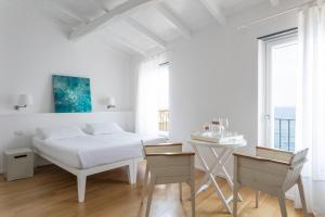 韦尔纳扎La Malà - camere di charme的白色卧室配有床和桌子