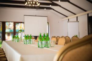 大谢尔皮亚Hotel Eljot的一张长桌子,上面装有绿瓶和玻璃杯