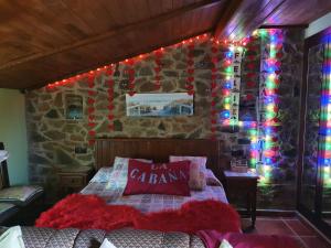 巴伦西亚德亚尔坎塔拉La Cabaña Romantica de Llano的卧室配有一张带圣诞灯的墙壁床。
