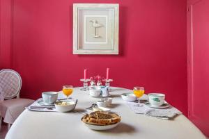 CroixLes Glycines的一间设有一张粉红色墙壁桌子的用餐室