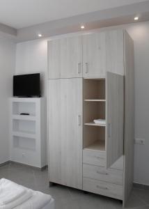 兹拉马Apartment Ori的一间带电视的客房内的白色橱柜